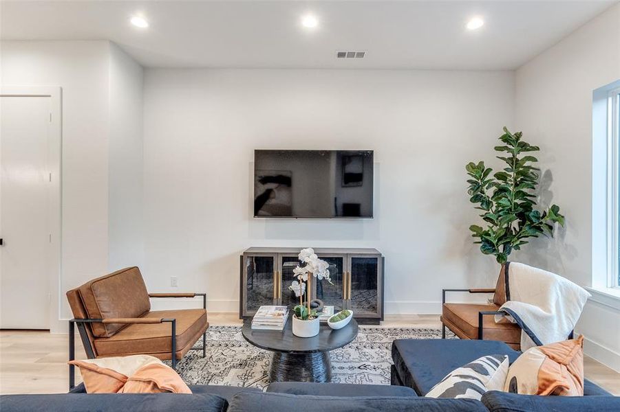 Living room with light hardwood / wood-style flooring and a premium fireplace