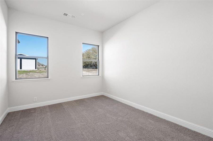 Carpeted empty room with baseboards Carpeted empty room with baseboards