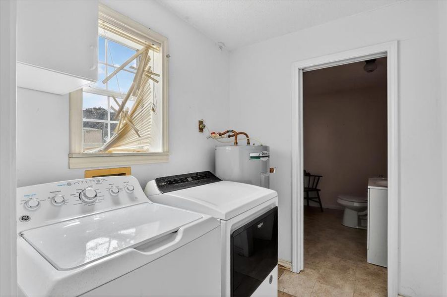 Laundry area featuring white walls, a window, half bath and a water heater