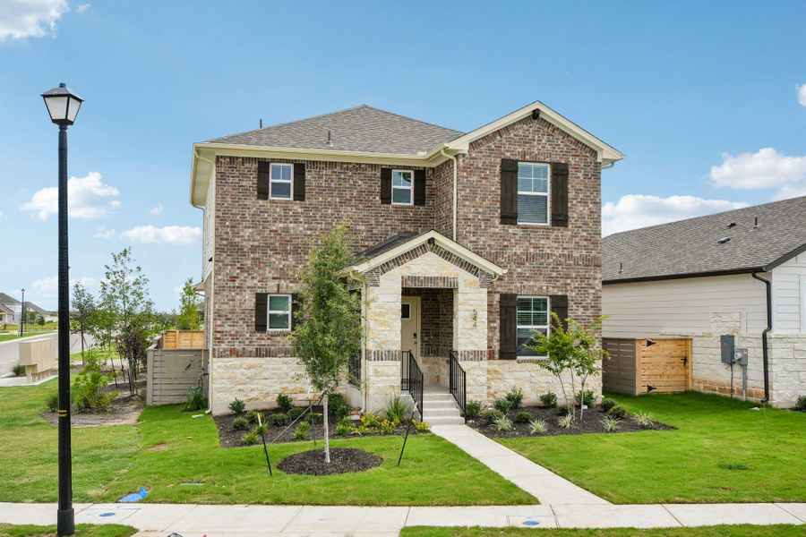View of front of property featuring brick siding, a shingled roof, stone siding, and a gate View of front of property featuring brick siding, a shingled roof, stone siding, and a gate