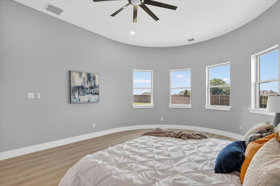 Curved wall featuring multiple windows, recessed lighting, and a ceiling fan
