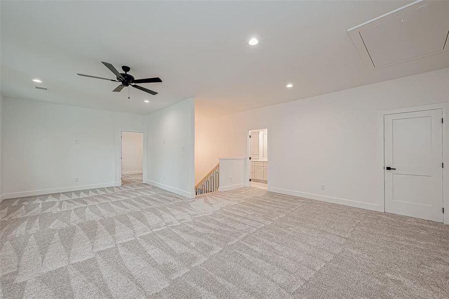 Spacious, second living area/game room with recessed lighting, and a ceiling fan.