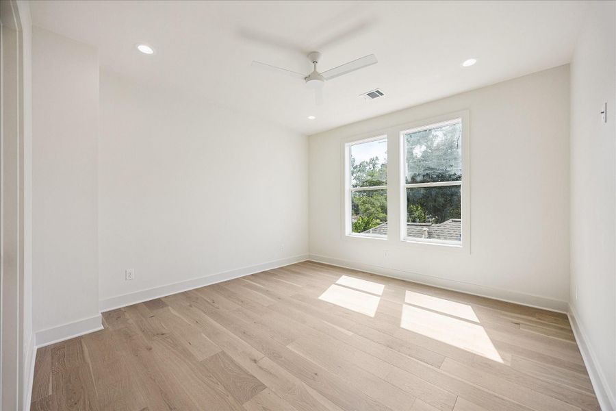 This inviting guest suite gives visitors a comfortable retreat of their own, with wide plank engineered white oak flooring, abundant natural light, a walk-in closet and ensuite access to a full bathroom.