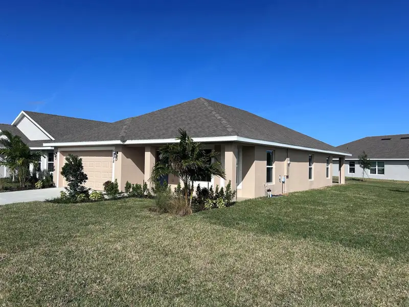 Front exterior of a new home in Waterstone 72, Fort Pierce, FL, highlighting curb appeal (Image 1). Front exterior of a new home in Waterstone 72, Fort Pierce, FL, highlighting curb appeal (Image 1).