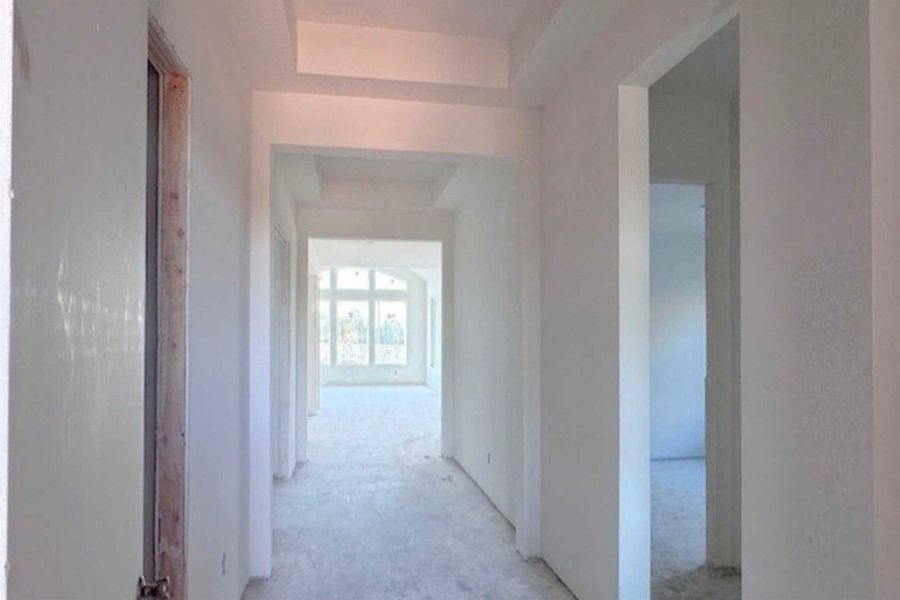 Corridor featuring a raised ceiling