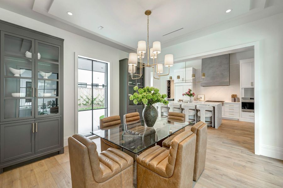 Dining room opens to the kitchen and has two cabinets with glass display shelves.