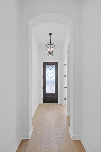 Doorway to outside featuring a chandelier and light wood finished floors