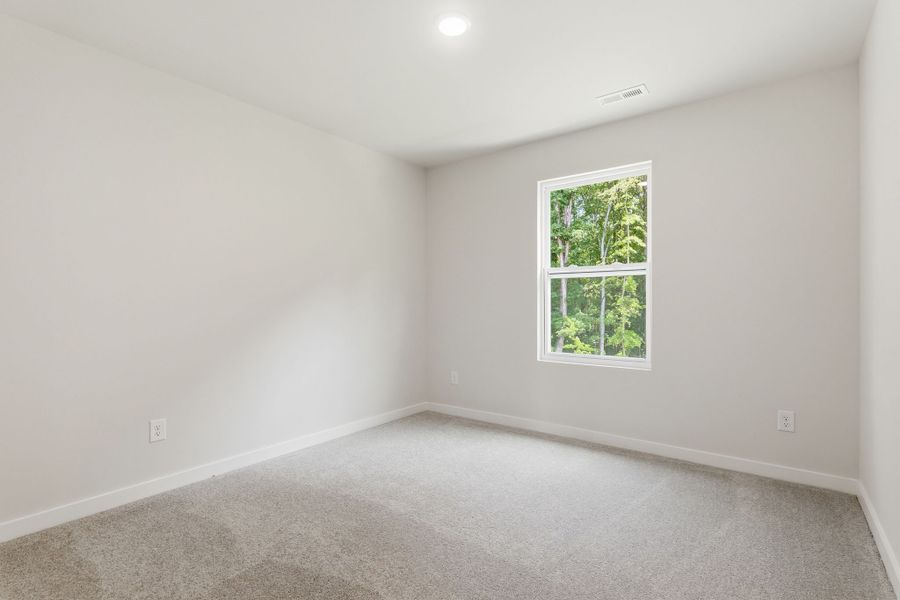 A room with a window and carpet.