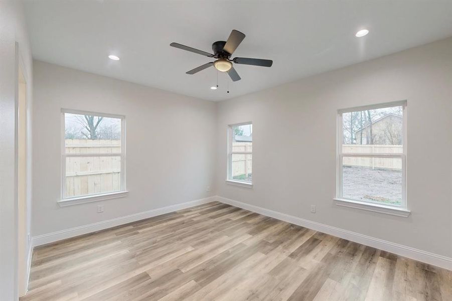 Unfurnished room with ceiling fan and light hardwood / wood-style flooring