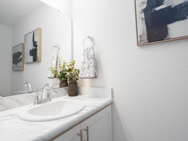 A convenient downstairs powder room is available for guests - Azalea townhome by Highland Homes