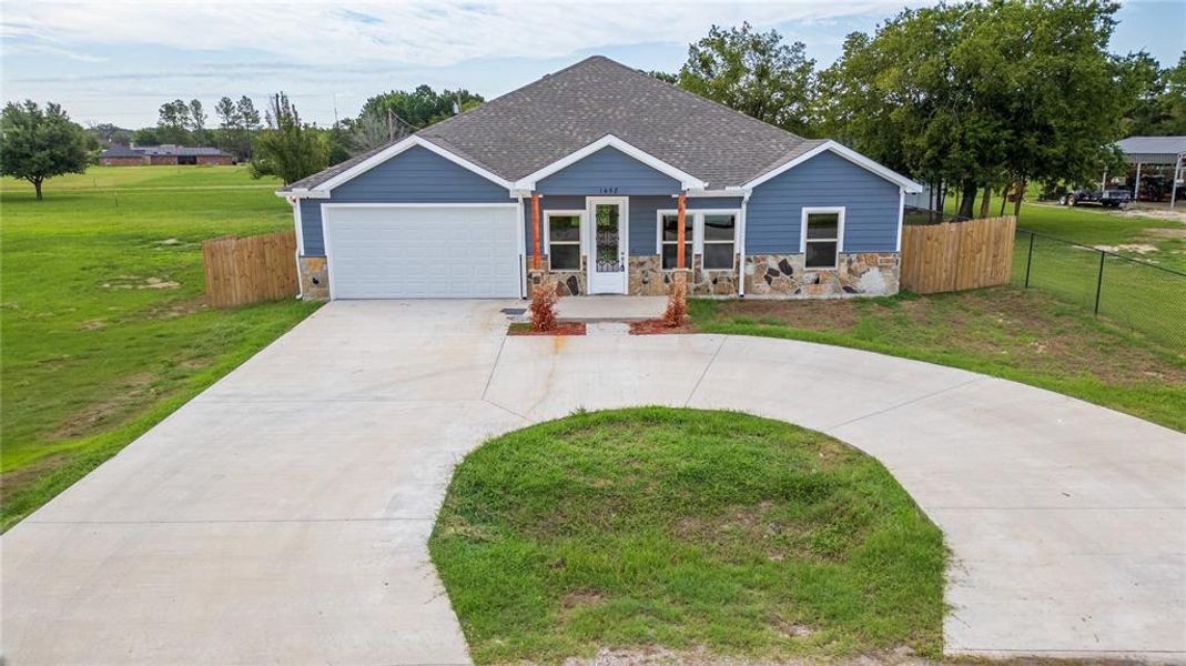 View of front facade with a garage and a front lawn