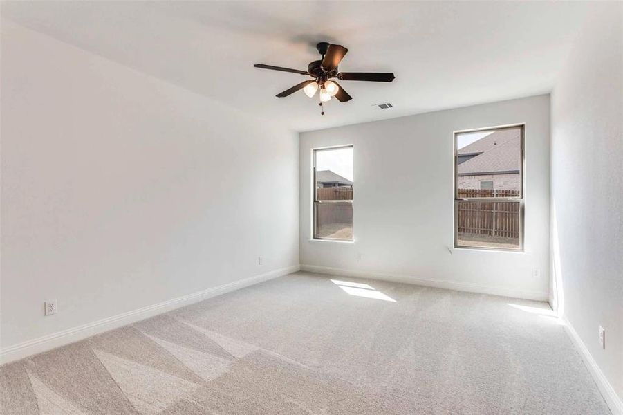 Spare room featuring carpet, baseboards, and a ceiling fan