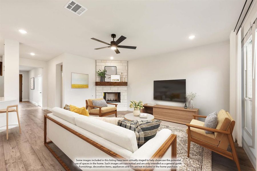 Living room with white sofa, brick fireplace, ceiling fan, and hardwood floors