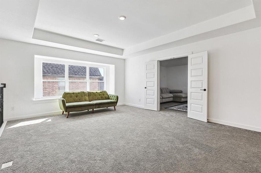 Unfurnished room with a tray ceiling and carpet flooring