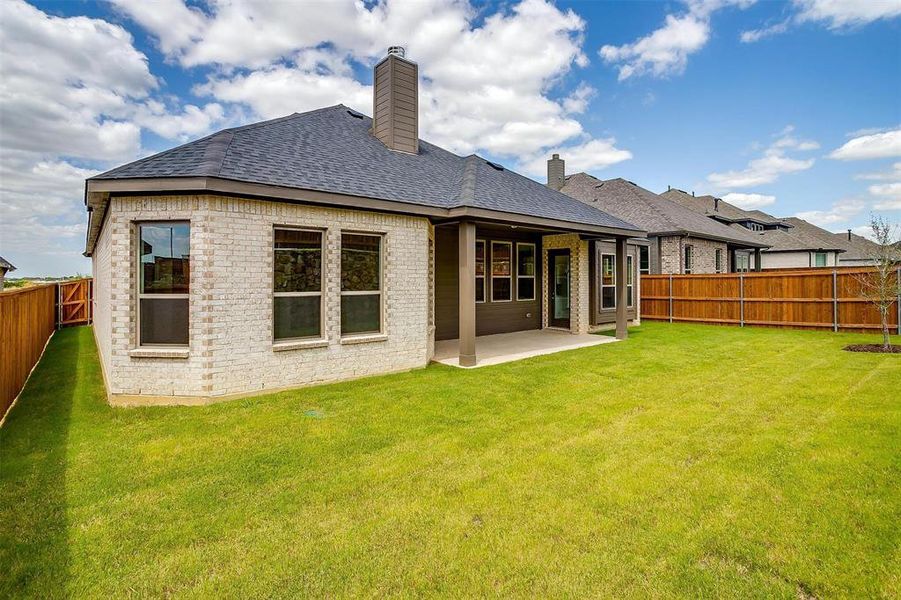 Back of house featuring a yard and a patio area