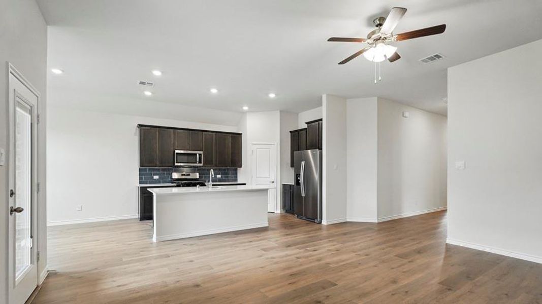 Open-concept living space featuring wood-finish flooring, recessed lighting, and a ceiling fan Open-concept living space featuring wood-finish flooring, recessed lighting, and a ceiling fan