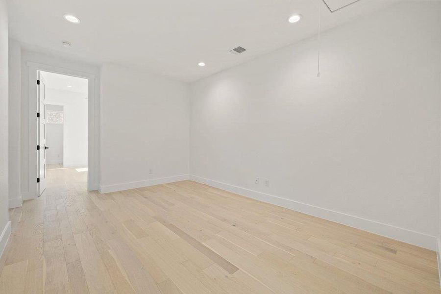 Empty room featuring light wood-style floors and recessed lighting