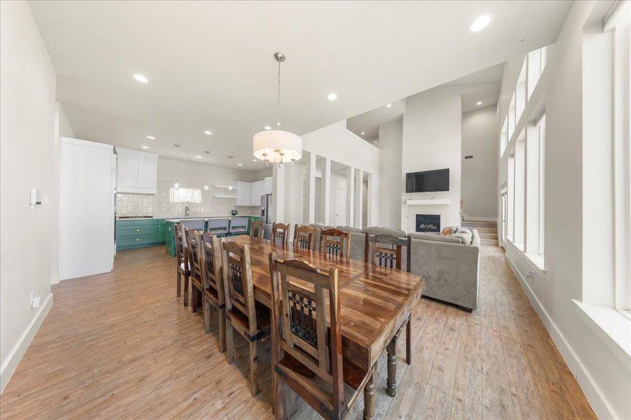 Dining room with light wood-style flooring, a fireplace, and recessed lighting Dining room with light wood-style flooring, a fireplace, and recessed lighting