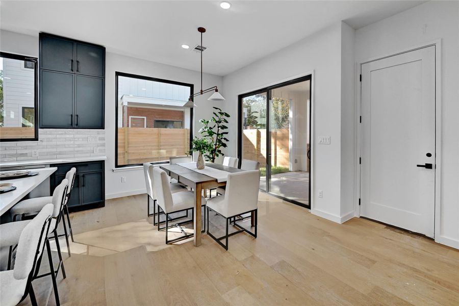 Dining area with recessed lighting and light wood-type flooring