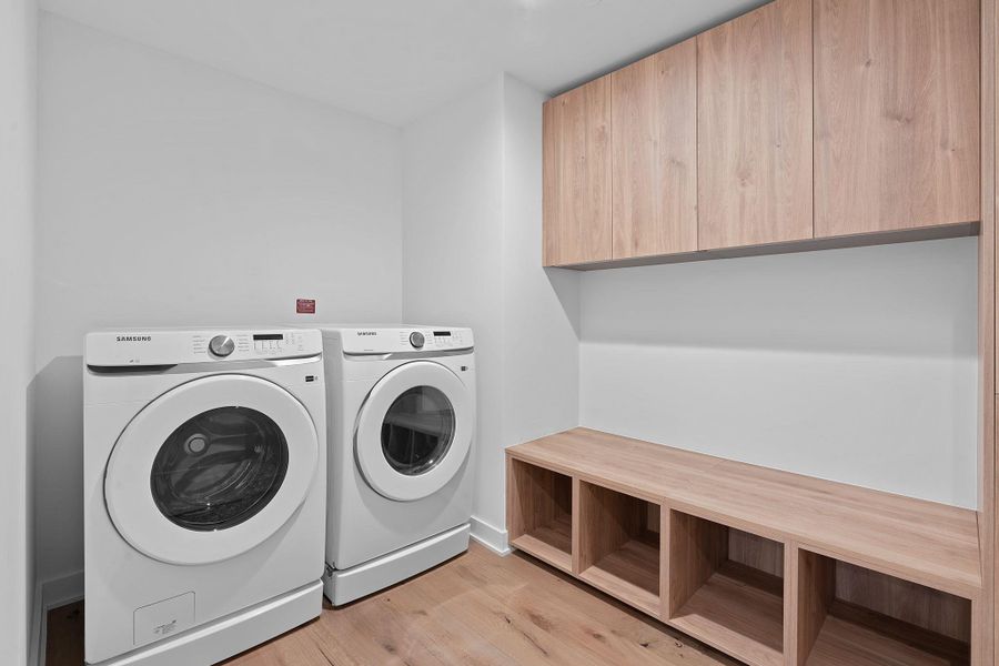 Laundry room featuring washing machine and dryer and light wood-style floors