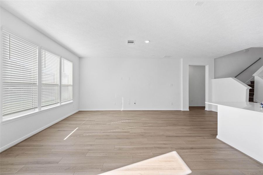 This Great Room is the perfect layout for entertaining or just relaxing. Whether it's simply a night in or entertaining family and friends, this home has ample open space for everyone to enjoy! Featuring vinyl plank flooring, large windows with privacy blinds, high ceilings, recessed lighting and custom paint!