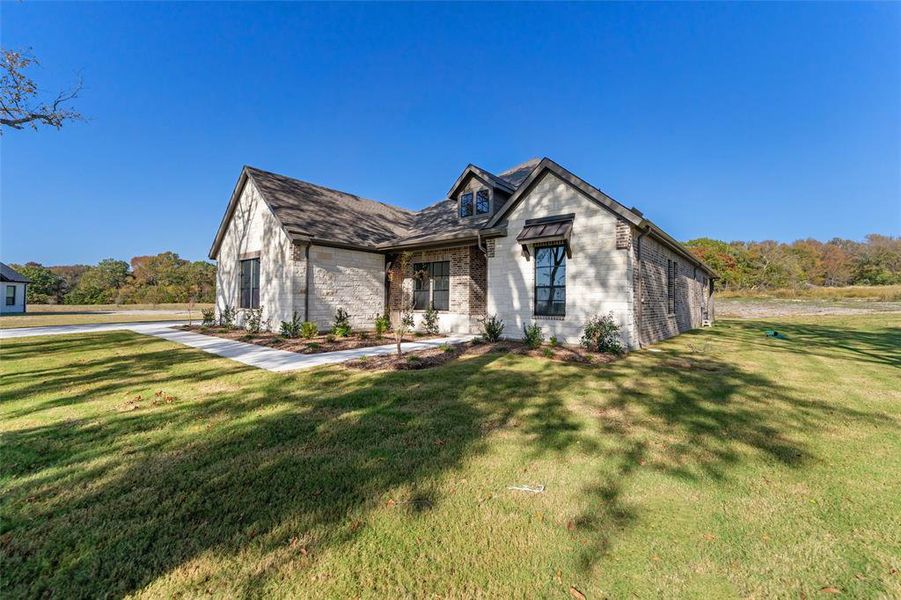 Front exterior of a new home in King Crossing Estates, Van Alstyne, TX, highlighting curb appeal (Image 25). Front exterior of a new home in King Crossing Estates, Van Alstyne, TX, highlighting curb appeal (Image 25).