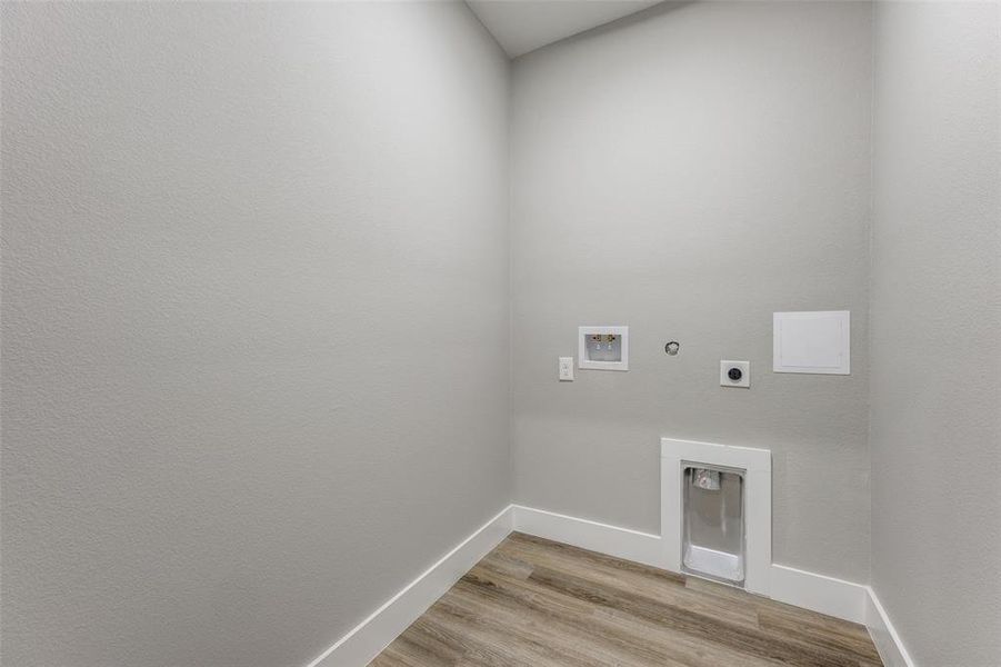 Laundry room featuring light wood-type flooring, gas dryer hookup, electric dryer hookup, and hookup for a washing machine