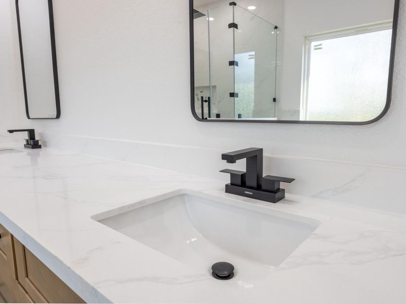 Stylish matte black faucets and frameless black-rimmed mirrors elevate the contemporary design, offering clean lines and high-end functionality. Stylish matte black faucets and frameless black-rimmed mirrors elevate the contemporary design, offering clean lines and high-end functionality.