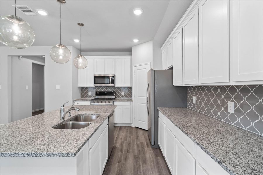 Discover this chef-ready kitchen featuring sleek, shaker-style white cabinetry, white sparkle granite countertops, and a full suite of stainless steel appliances, including an over-the-range microwave and a side-by-side refrigerator. Discover this chef-ready kitchen featuring sleek, shaker-style white cabinetry, white sparkle granite countertops, and a full suite of stainless steel appliances, including an over-the-range microwave and a side-by-side refrigerator.