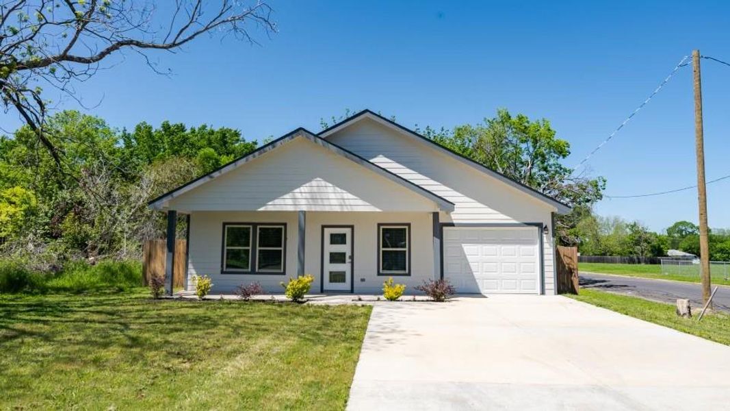 View of front of house featuring a front yard and a garage View of front of house featuring a front yard and a garage