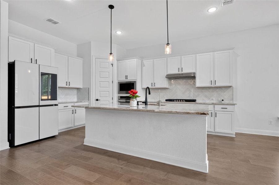 Elegant hardwood flooring grounds a modern culinary space anchored by a central kitchen island. Elegant hardwood flooring grounds a modern culinary space anchored by a central kitchen island.