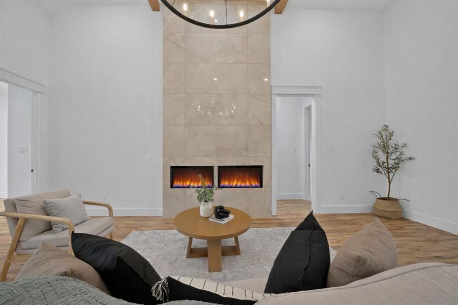 This inviting living space features high ceilings, light hardwood floors, and a modern fireplace with two inserts