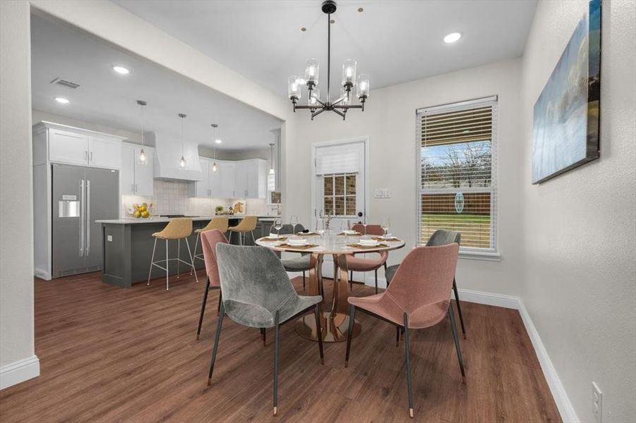 Dining space with dark wood-type flooring and a chandelier