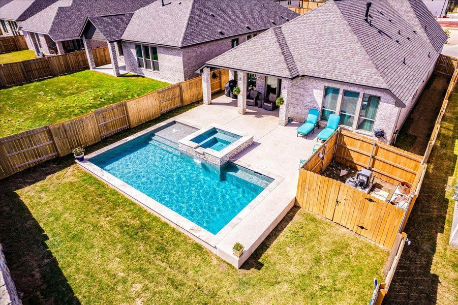 Combined pool / hot tub featuring a patio and a fenced backyard