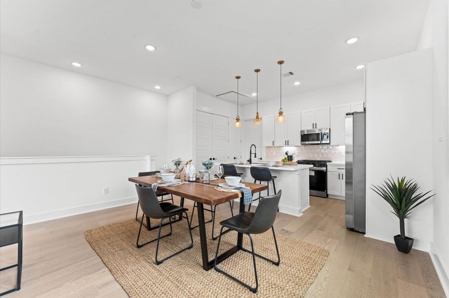 This inviting dining space sits perfectly between the modern kitchen and comfortable living room, creating a natural flow ideal for entertaining and everyday living. The open layout allows for effortless interaction across zones, while stylish lighting and tasteful furnishings define the area without disrupting the spacious feel. Whether hosting dinner parties or enjoying casual meals, this central hub brings warmth and connectivity to the heart of the home.