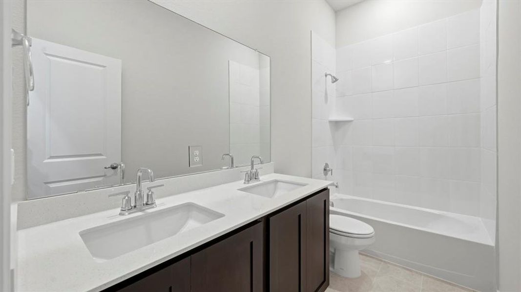 Full bath featuring double vanity, shower / washtub combination, and light tile patterned floors Full bath featuring double vanity, shower / washtub combination, and light tile patterned floors