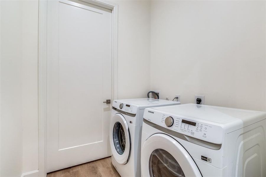 Washroom featuring washer hookup, light hardwood / wood-style floors, washer and clothes dryer, and electric dryer hookup