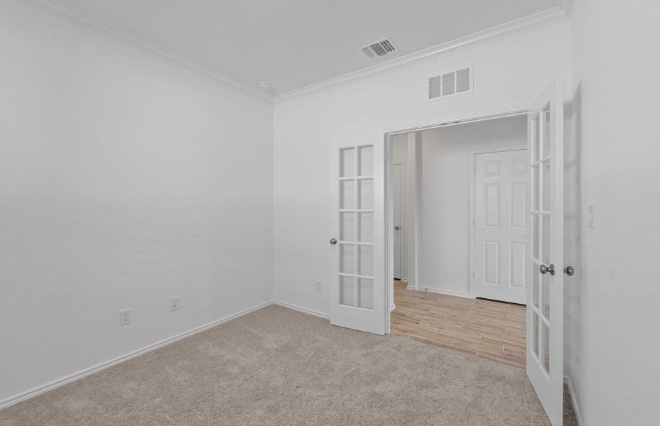 Spare room with crown molding, french doors, and light carpet Spare room with crown molding, french doors, and light carpet