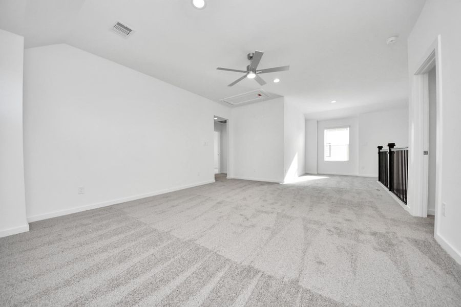 Discover a haven of leisure in this fantastic game room! Whether you're seeking a casual hangout or an adult gaming retreat, this space has it all. Enjoy the luxurious feel of plush carpet underfoot, the expansive ambiance of high ceilings, custom paint that adds a touch of personality, and windows that flood the room with refreshing natural light. Sample photo of completed home with similar floor plan. Actual colors and selections may vary.