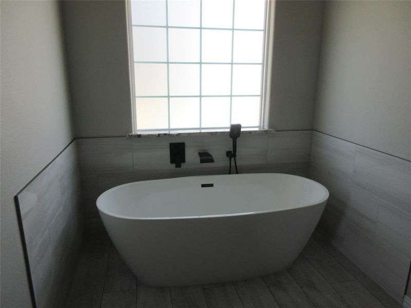 Bathroom featuring tile walls and a washtub