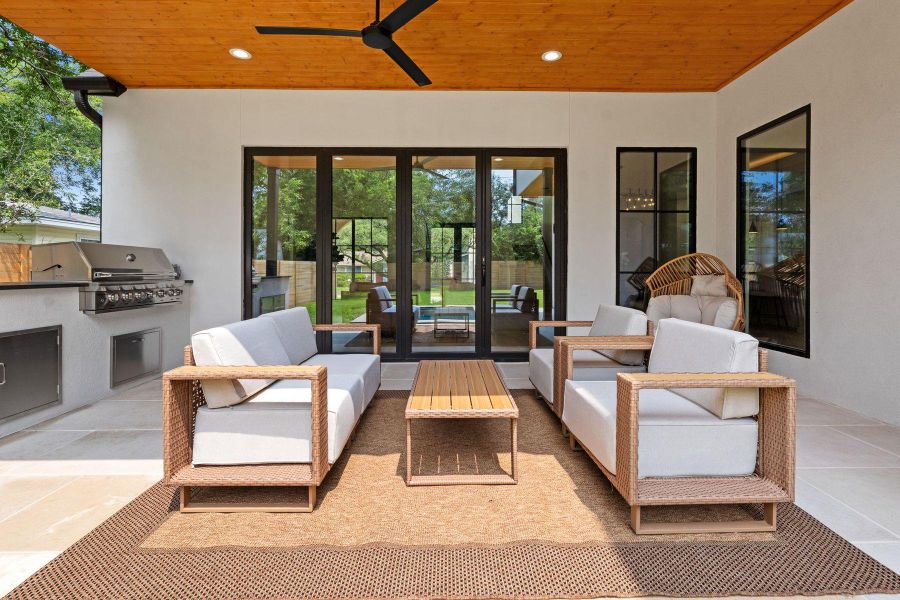 An inviting outdoor living space features an integrated barbecue and ample seating under a wood-paneled ceiling. An inviting outdoor living space features an integrated barbecue and ample seating under a wood-paneled ceiling.