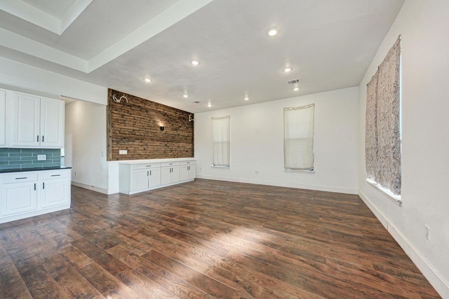 Gleaming wood floors anchor this open area alongside a rustic wood-plank accent wall.