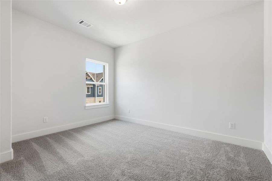 This room features light grey walls, a single window, and grey carpet