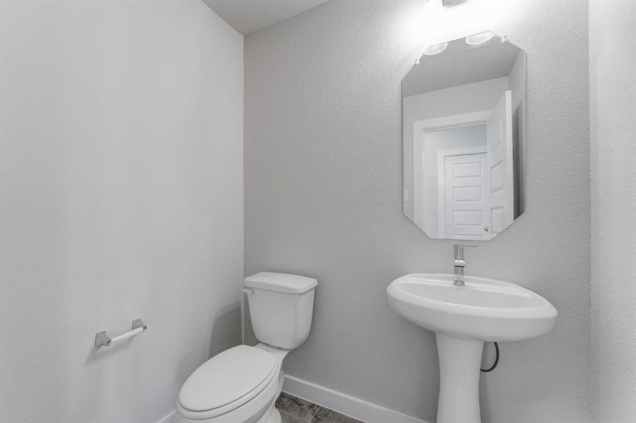 Immerse yourself in modern elegance within this delightful half bathroom. Sample photo of completed home with similar floor plan. As-built interior colors and selections may vary.