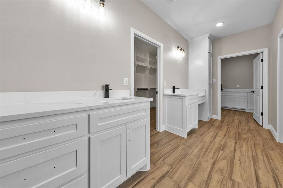 Bathroom featuring wood finished floors, vanity, a spacious closet, and recessed lighting Bathroom featuring wood finished floors, vanity, a spacious closet, and recessed lighting