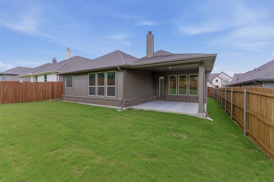 Expansive backyard featuring a covered patio, a manicured lawn, and privacy fencing