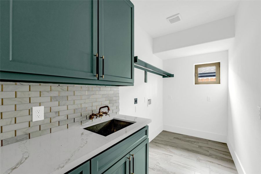With lots of cabinet space and a handy utility sink, this bright and stylish laundry room is as functional as it is beautiful.