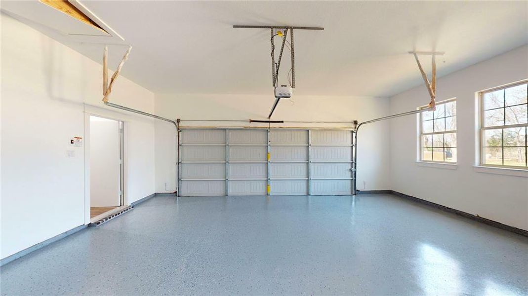 Garage featuring baseboards and a garage door opener