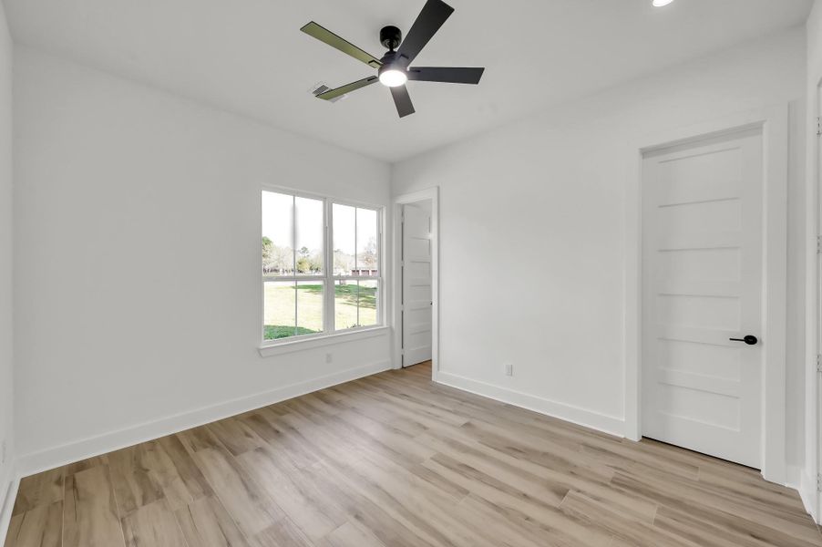 Comfortable secondary bedroom with full ensuite bathroom large window, modern ceiling fan, and neutral finishes ready for personalization.