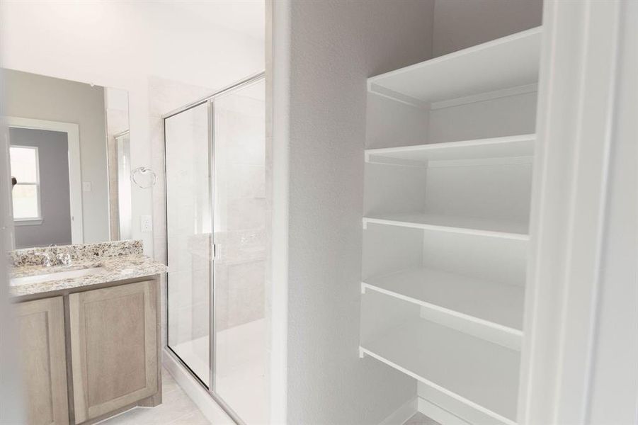 Bathroom with vanity, an enclosed shower, and tile patterned flooring